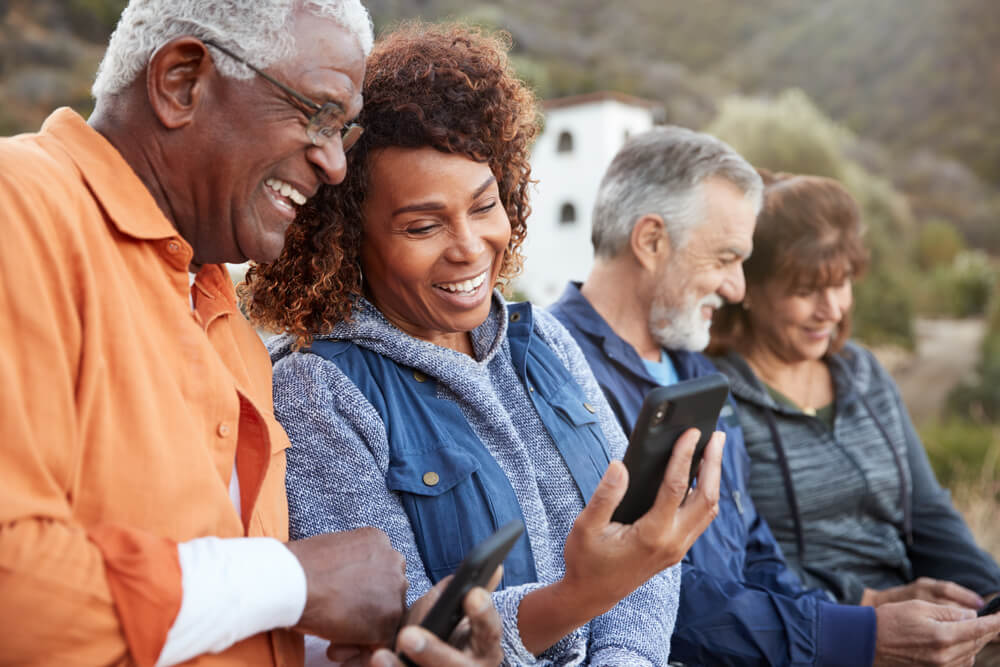 Glückliche Senioren schauen auf ein Handy