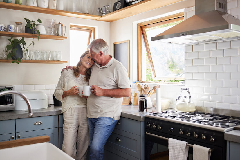 Ehepaar steht Arm in Arm in der Küche