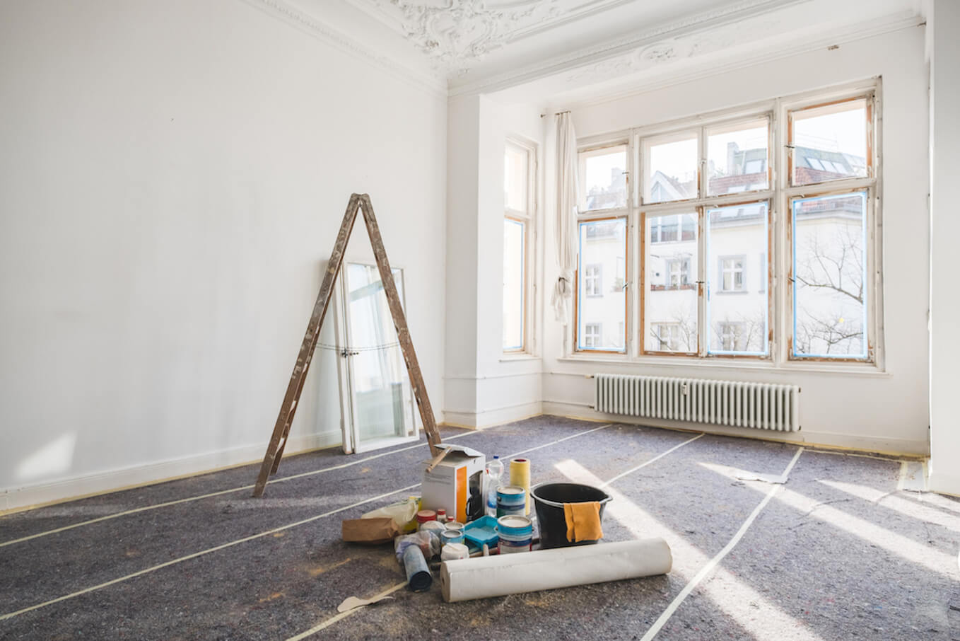 Leiter und Werkzeug in einem sanierten Zimmer 